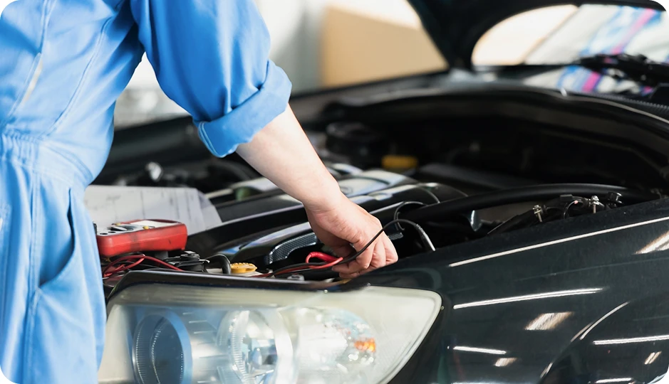 自動車のボンネットを開けて点検する整備士