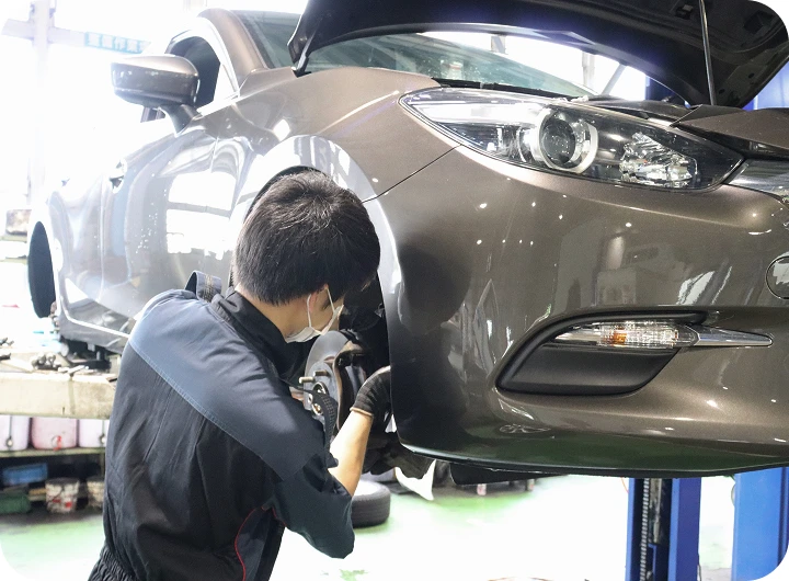 threeColumnsDetails__list__item__image リフトアップされた車を整備する作業員